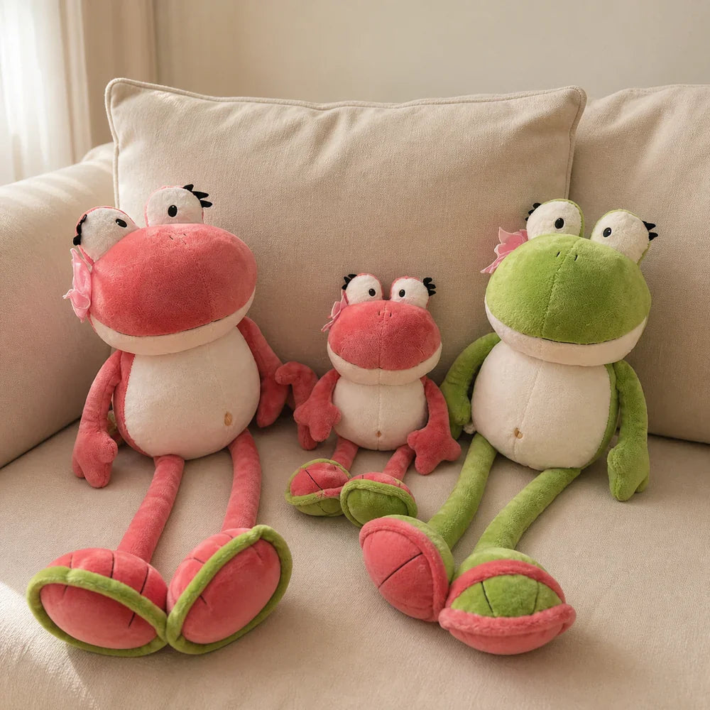 Pink and Green Frog Plush Toy Family on a Cream Sofa
