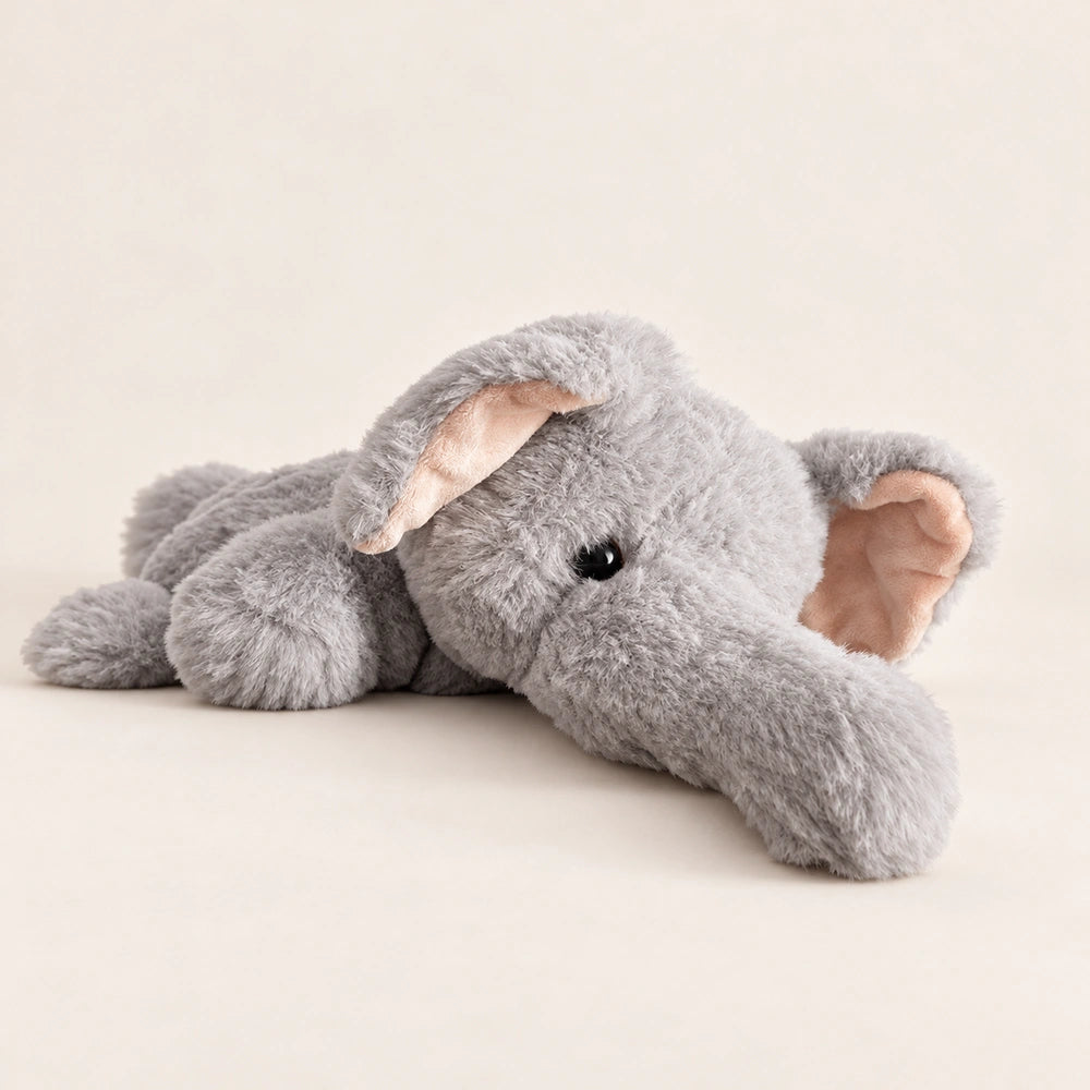 Gray elephant plush lying down with its head tilted and trunk resting on the surface.