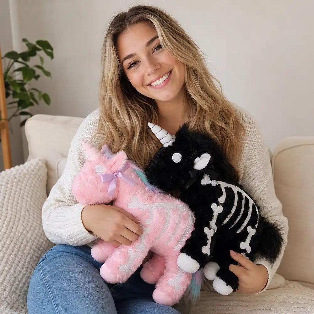 Woman Holding Pink and Black Skeleton Unicorn Plushes