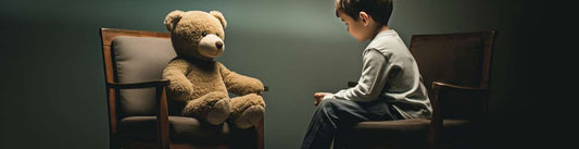 A boy sit against a teddy bear