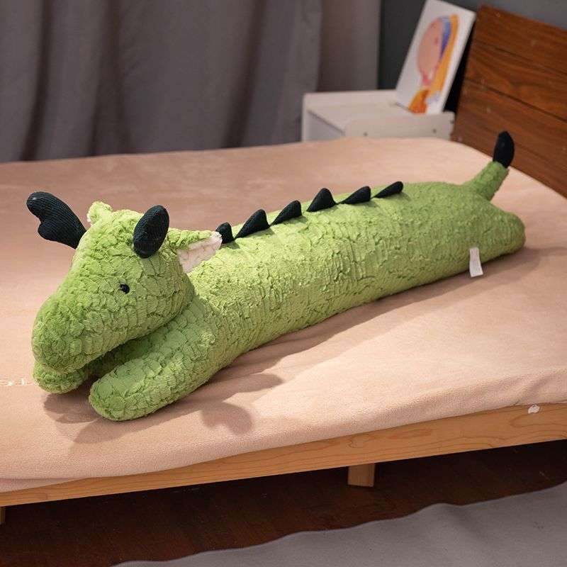 green dragon pillow on bed