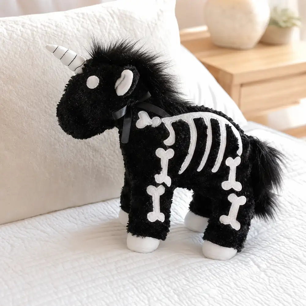 Black Skeleton Unicorn Plush on a White Bed