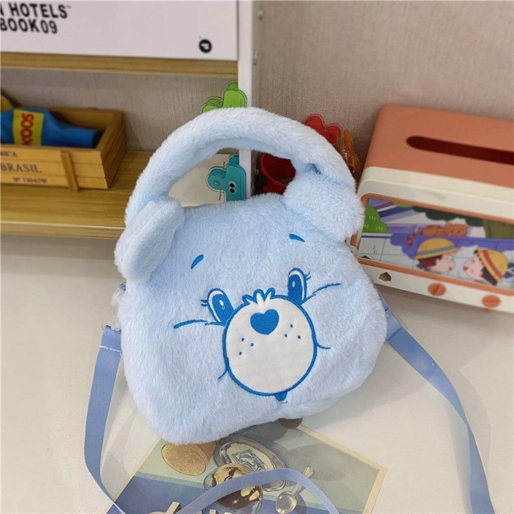 Blue Care Bear plush handbag with a heart-shaped patch, perfect for kids.