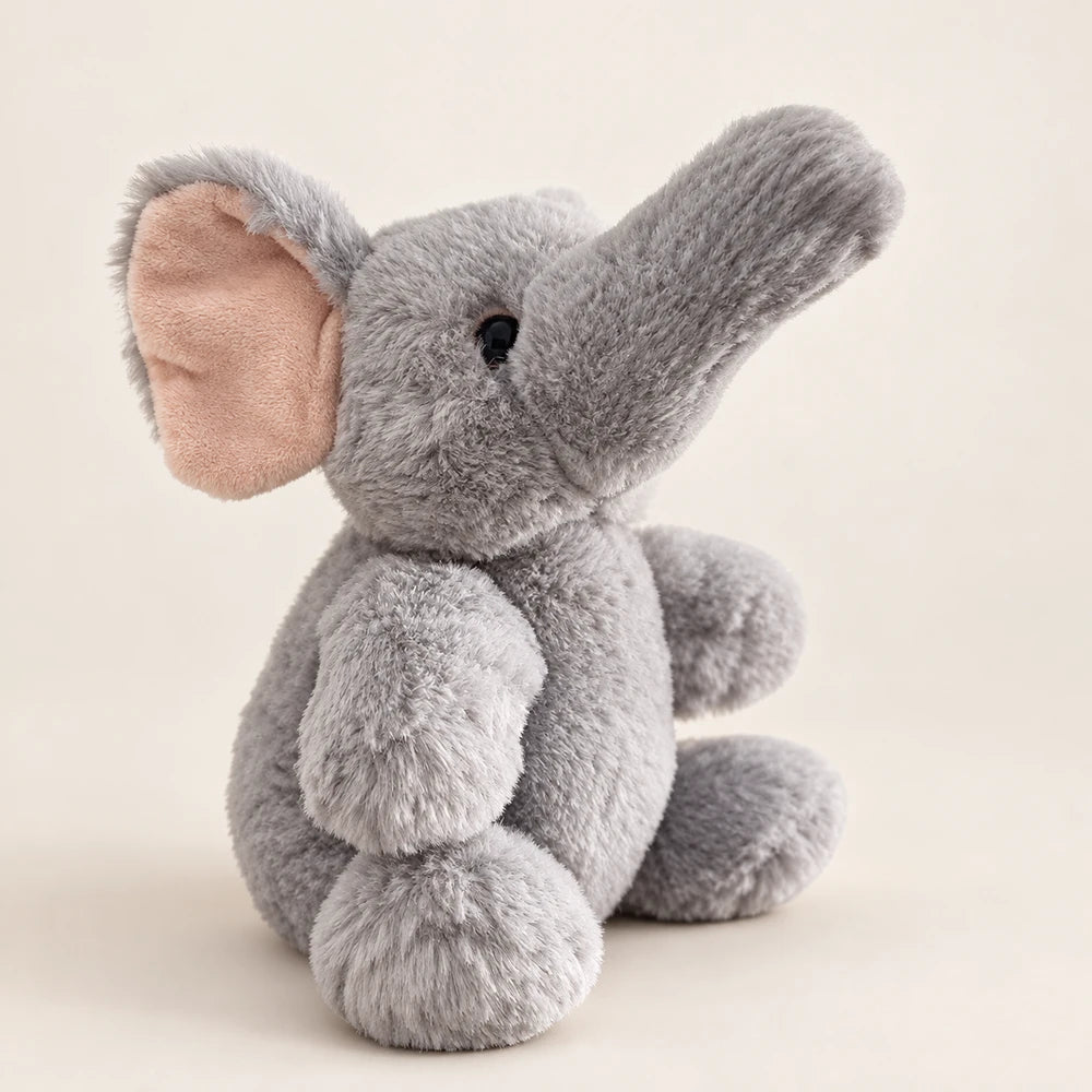 Gray elephant stuffed animal in a side view with its trunk raised and a pale pink inner ear.