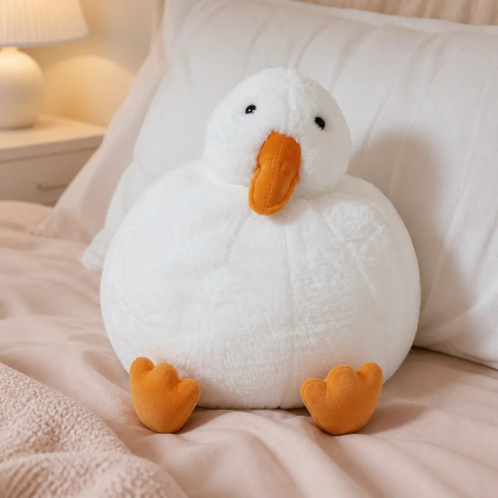 White Duck Plush by a White Pillow