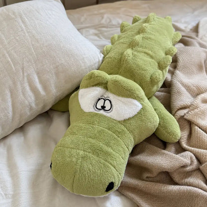 Light green 100cm crocodile plush on a cozy bed with a knit throw