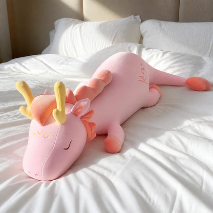 Pink Lovely Herbivore Dragon Plush Resting on a Bright White Bed
