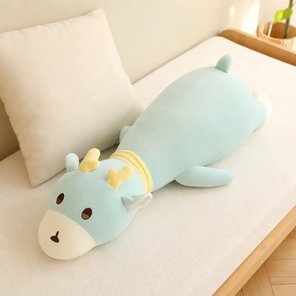 Mint Long Deer Body Pillow Plush on a Cream Daybed