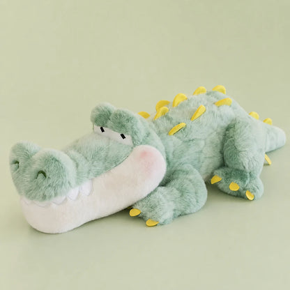 Mint green crocodile long pillow plush with yellow back spikes on a sage studio backdrop