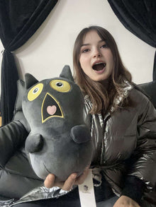 a model holds a plushthis shocked cat plushie