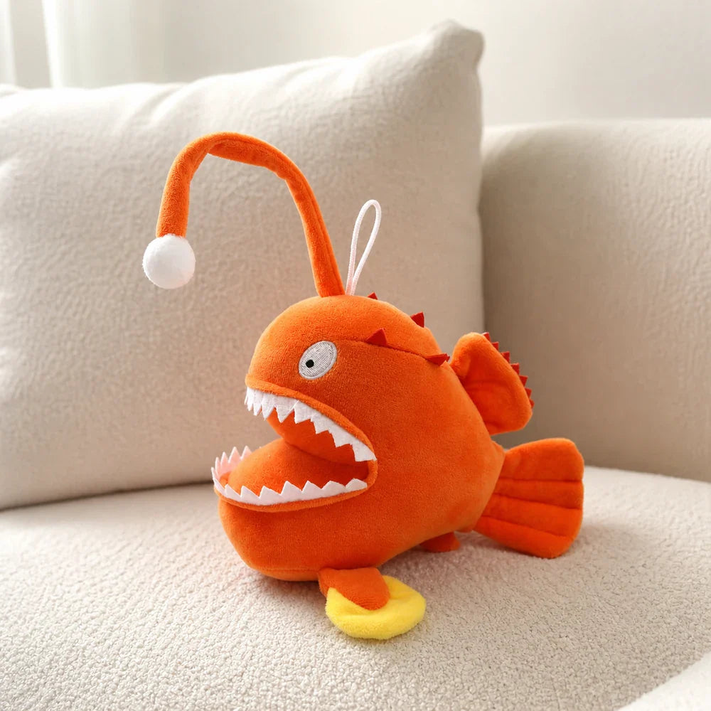 Cartoon Orange Anglerfish Plush Toy on a Cream Sofa