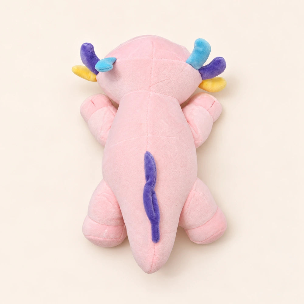 Overhead back view of the Pastel Gills axolotl plush showing smooth pink fabric, colorful gills, and a purple fin.