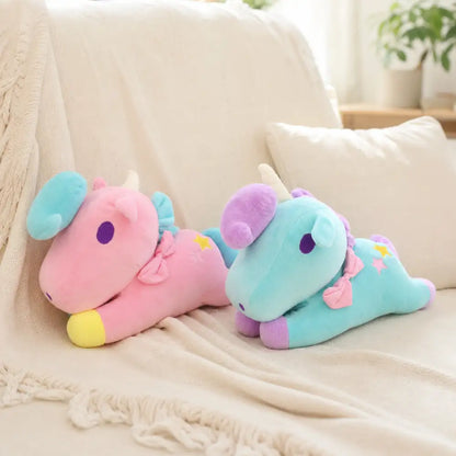 Pink and turquoise pastel unicorn plush toys on a cozy sofa