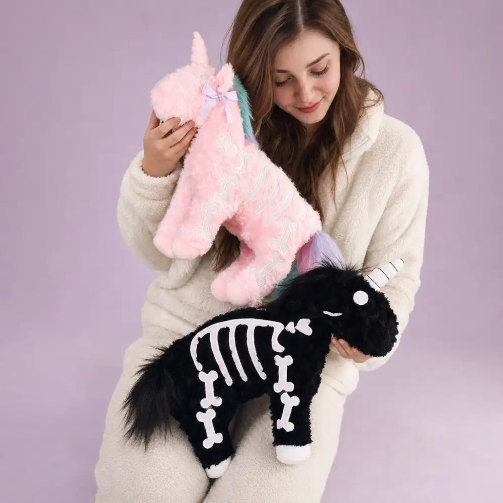 Pink and Black Skeleton Unicorn Plushes with Woman – Studio View