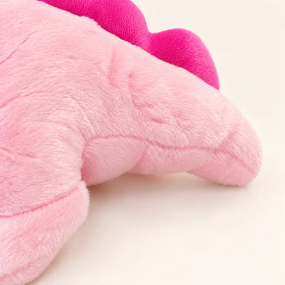 Close-up of the pink axolotl plush showing short-pile fabric, stitched seams, and the bright pink fin.