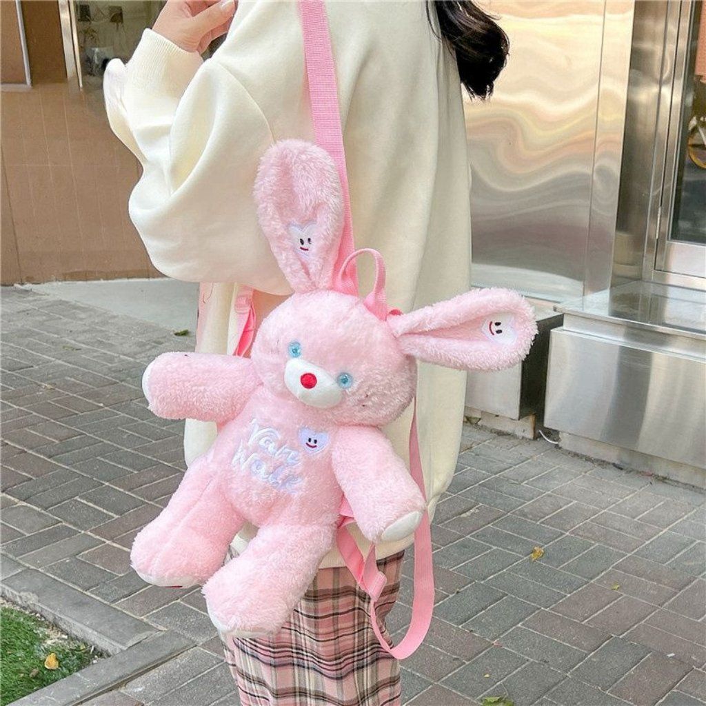 Pink bunny plush backpack with cute ears and a heart-shaped patch, perfect for kids