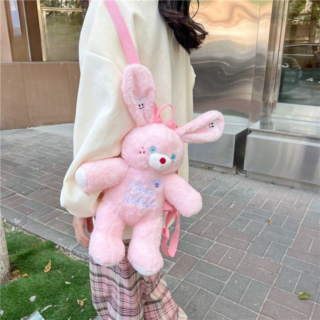 Pink bunny plush backpack with cute ears and a heart-shaped patch, perfect for kids