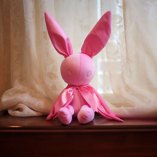 A bunny plush sitting on the window