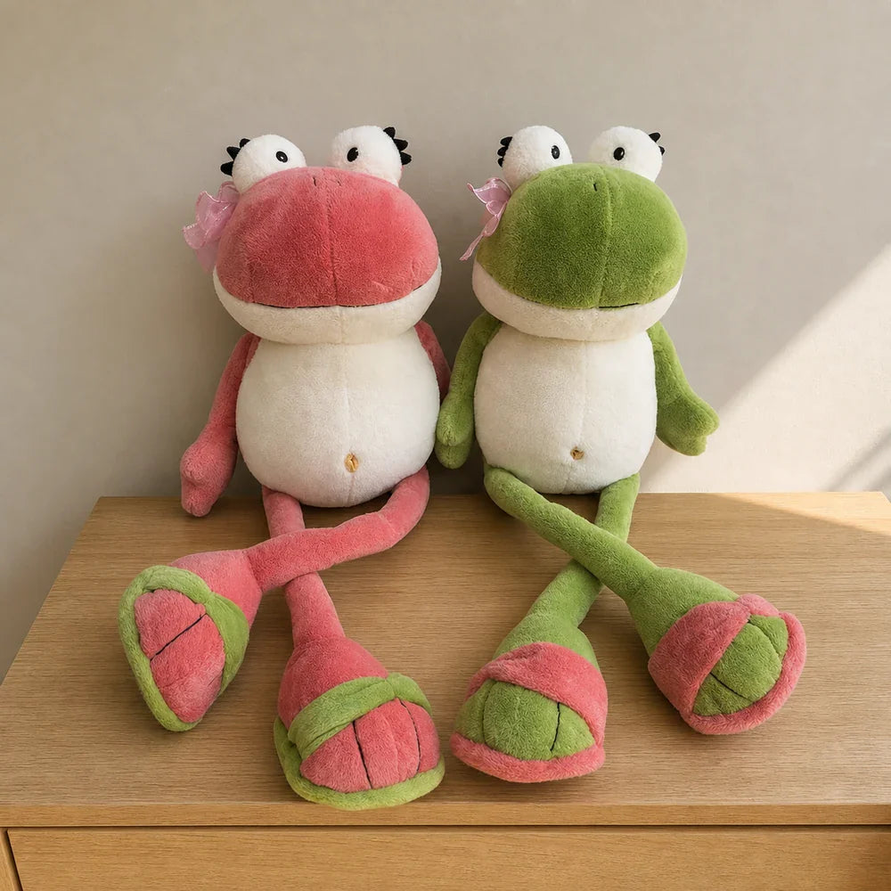 Pink and Green Frog Plush Toys on an Oak Table