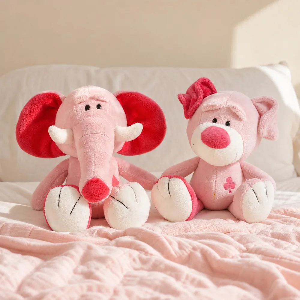 Pink Love Elephant and Pig Plush on a Bedroom Bed
