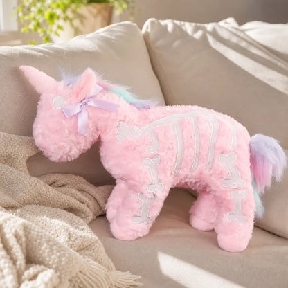 Pink Skeleton Unicorn Plush on a Cream Sofa