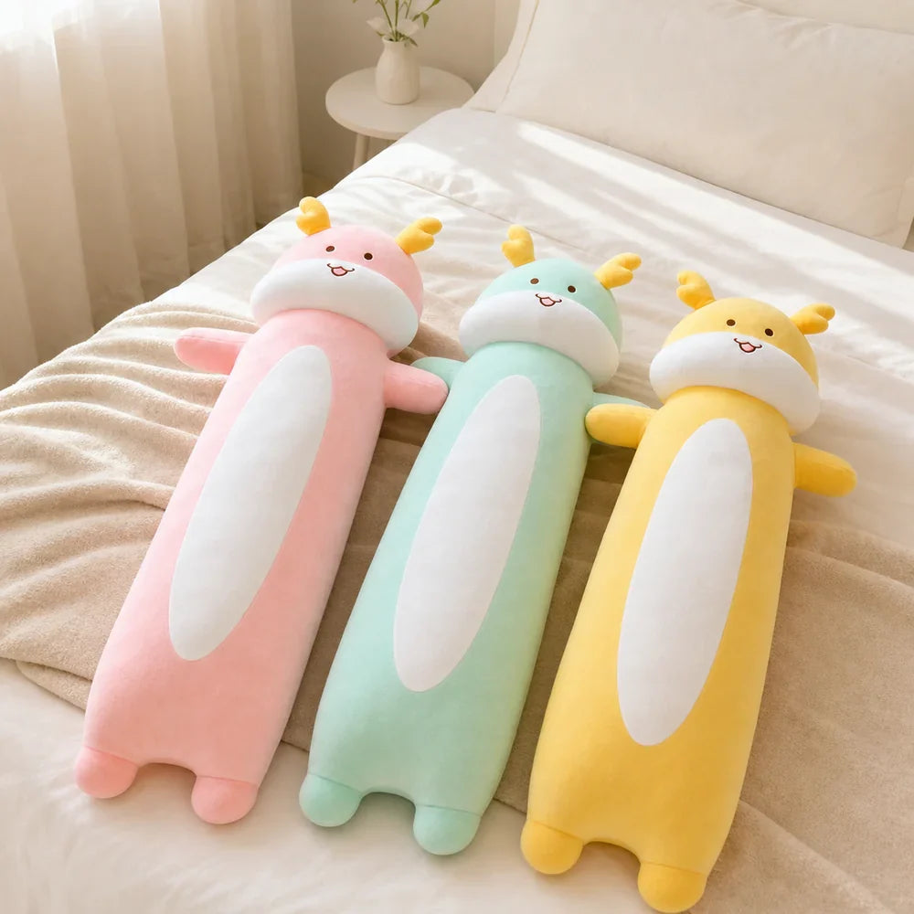 Pink Mint Green and Yellow Long Dragon Plush Toys on a Bed