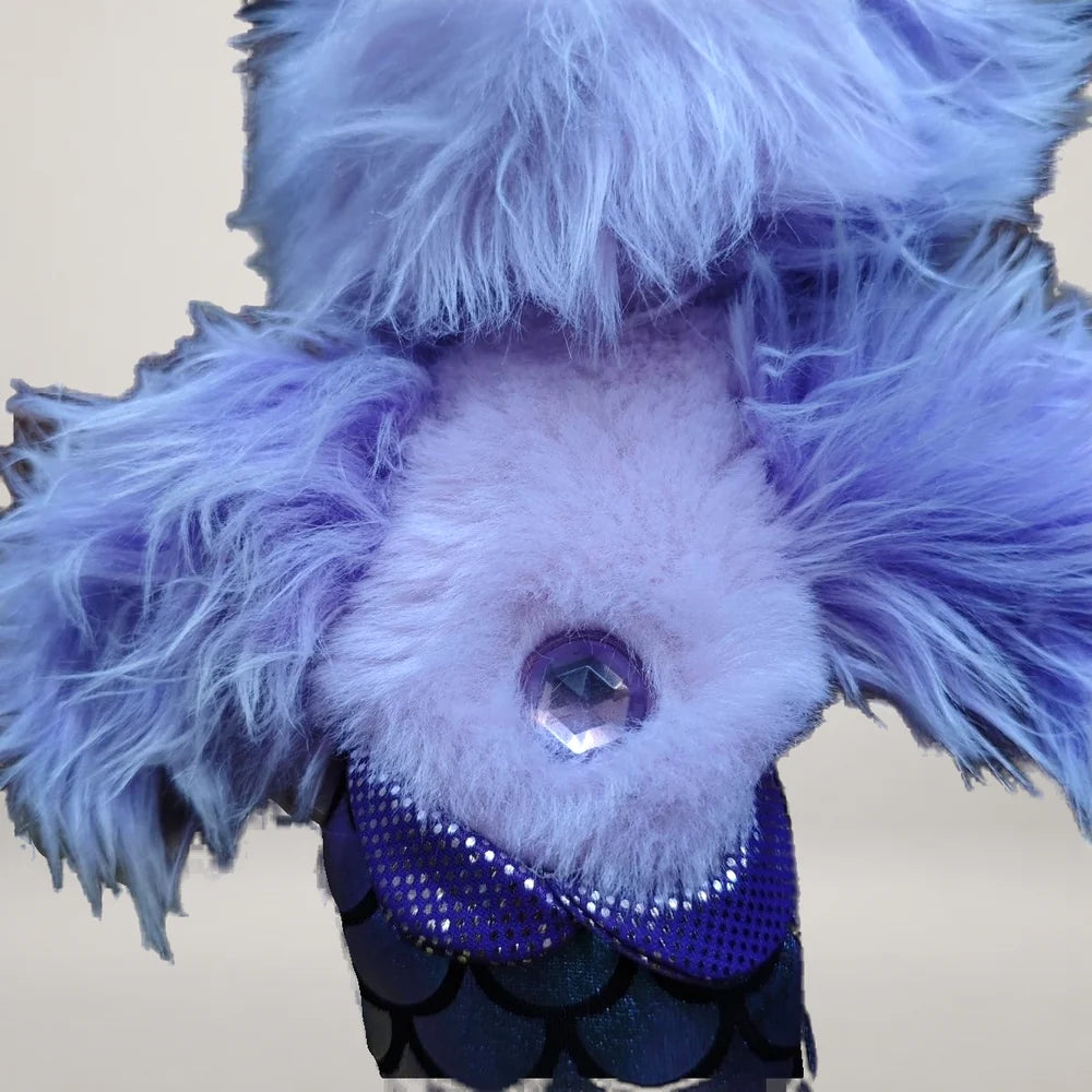Close-up of the purple belly jewel and shiny scale-pattern tail on the mermaid dog plush.