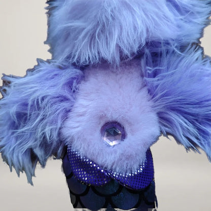 Close-up of the purple belly jewel and shiny scale-pattern tail on the mermaid dog plush.