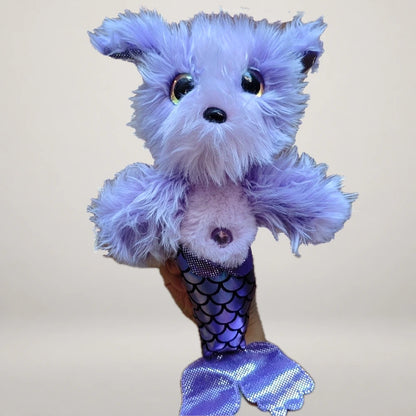 Purple mermaid dog plush held in one hand, showing its scale-pattern tail and shiny fins.