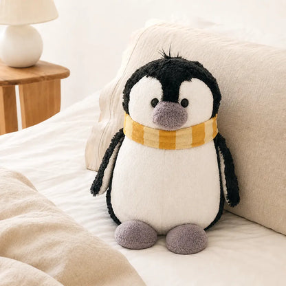 Yellow Scarf Penguin Plush Toy on a Cozy Bed