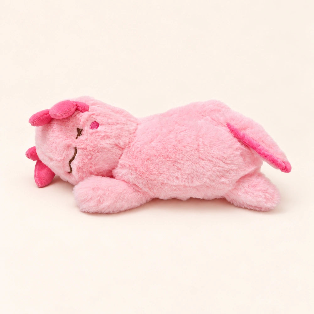 Side view of the Sleepy Pink axolotl plush showing fluffy pink fabric, embroidered facial details, and a pink tail fin.