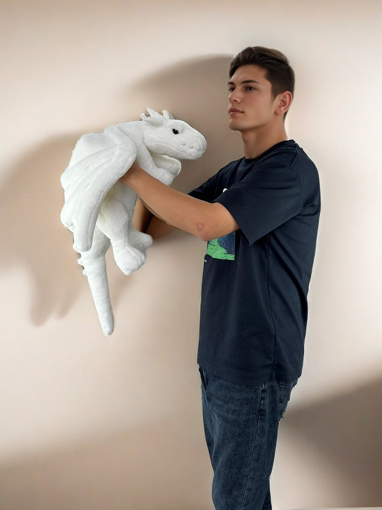a guy holds a PlushThis snow dragon plush