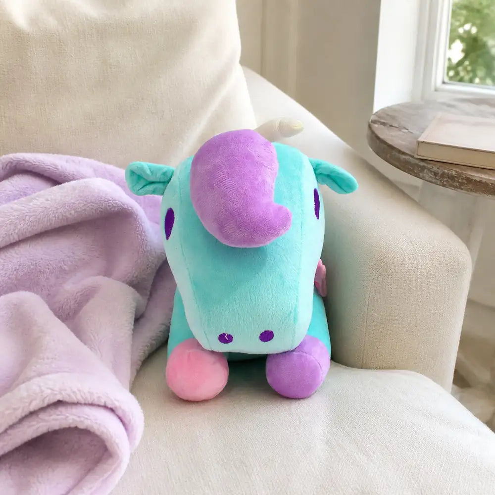 Turquoise pastel unicorn plush toy on a sunlit chair
