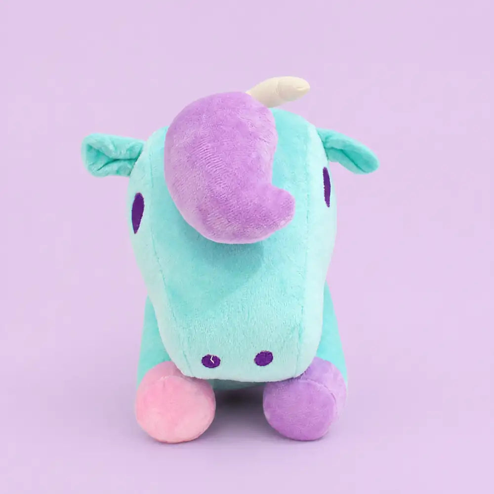 Turquoise pastel unicorn plush toy front view on a lavender studio background