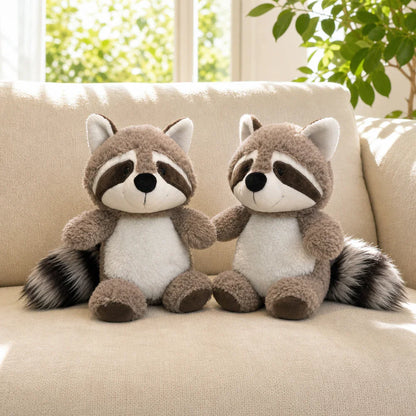 Two Cute Gray Raccoon Plush Toys on a Cream Sofa